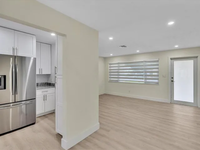 a view of an empty room with a kitchen