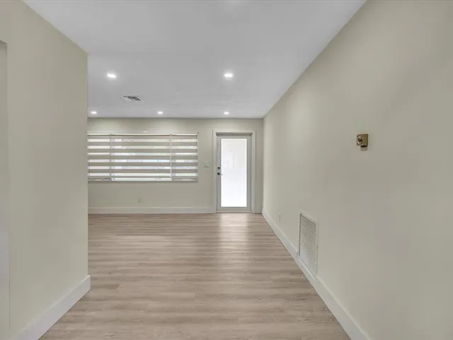 a view of hallway with wooden floor