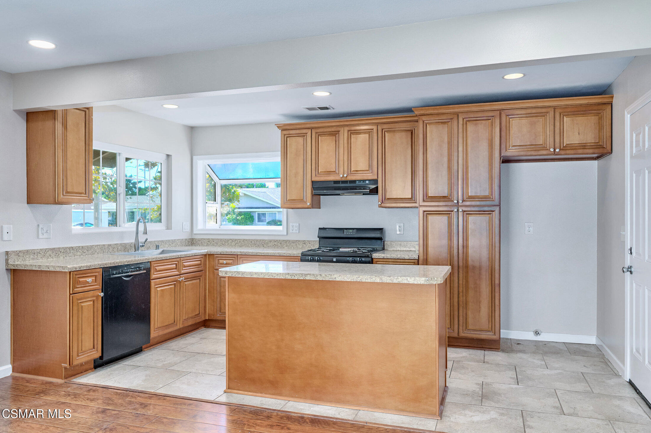 560 Randy Drive Newbury Park, CA 91320 - Photo 4 of 39 a kitchen with kitchen island granite countertop wooden cabinets a refrigerator a sink a stove and a window