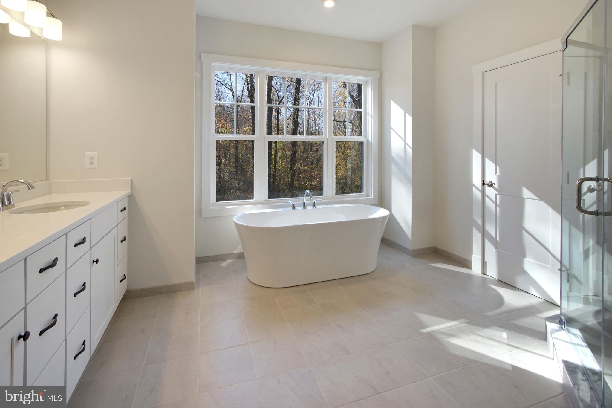 7405 Copper Lake Drive Hanover, MD 21076 - Photo 25 of 36 a bathroom with a tub sink and mirror