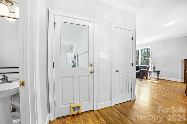 a view of a livingroom with wooden floor and a bathroom space