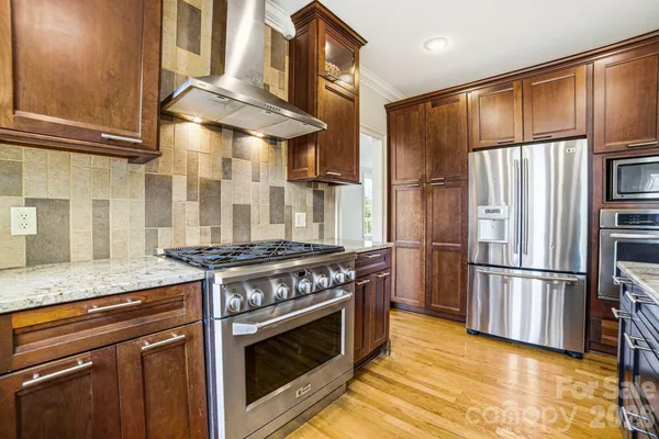 a kitchen with stainless steel appliances granite countertop a stove a refrigerator and a refrigerator