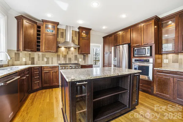 a kitchen with stainless steel appliances granite countertop a stove and cabinets