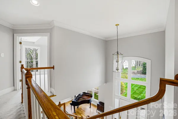 a view of a hallway with windows and chandelier