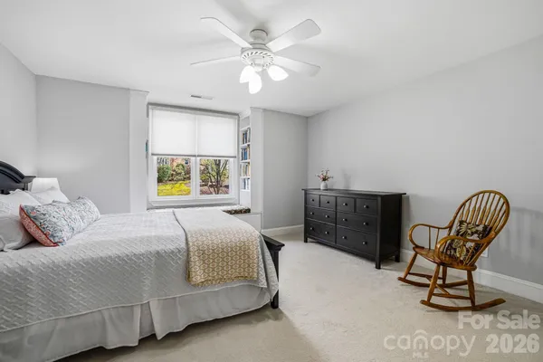 a bedroom with a bed a chair and a window