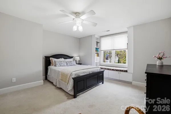 a spacious bedroom with a bed and a chandelier