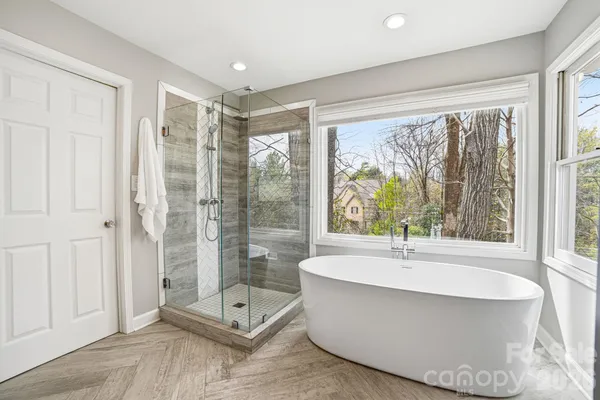 a bathroom with a large tub shower and sink