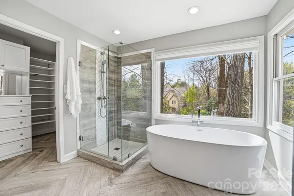 a spacious bathroom with a tub shower and window