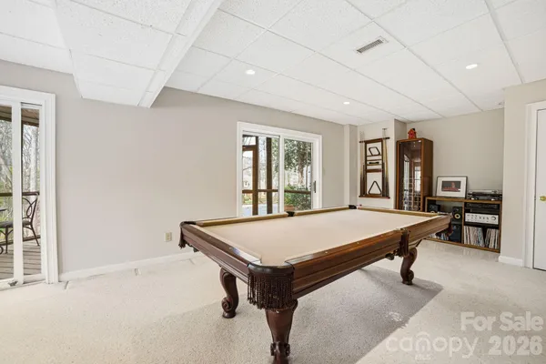 a room with pool table and windows