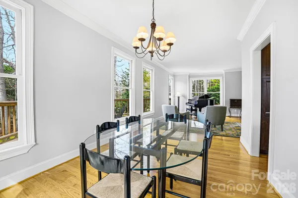 a view of a dining room with furniture a chandelier and a window