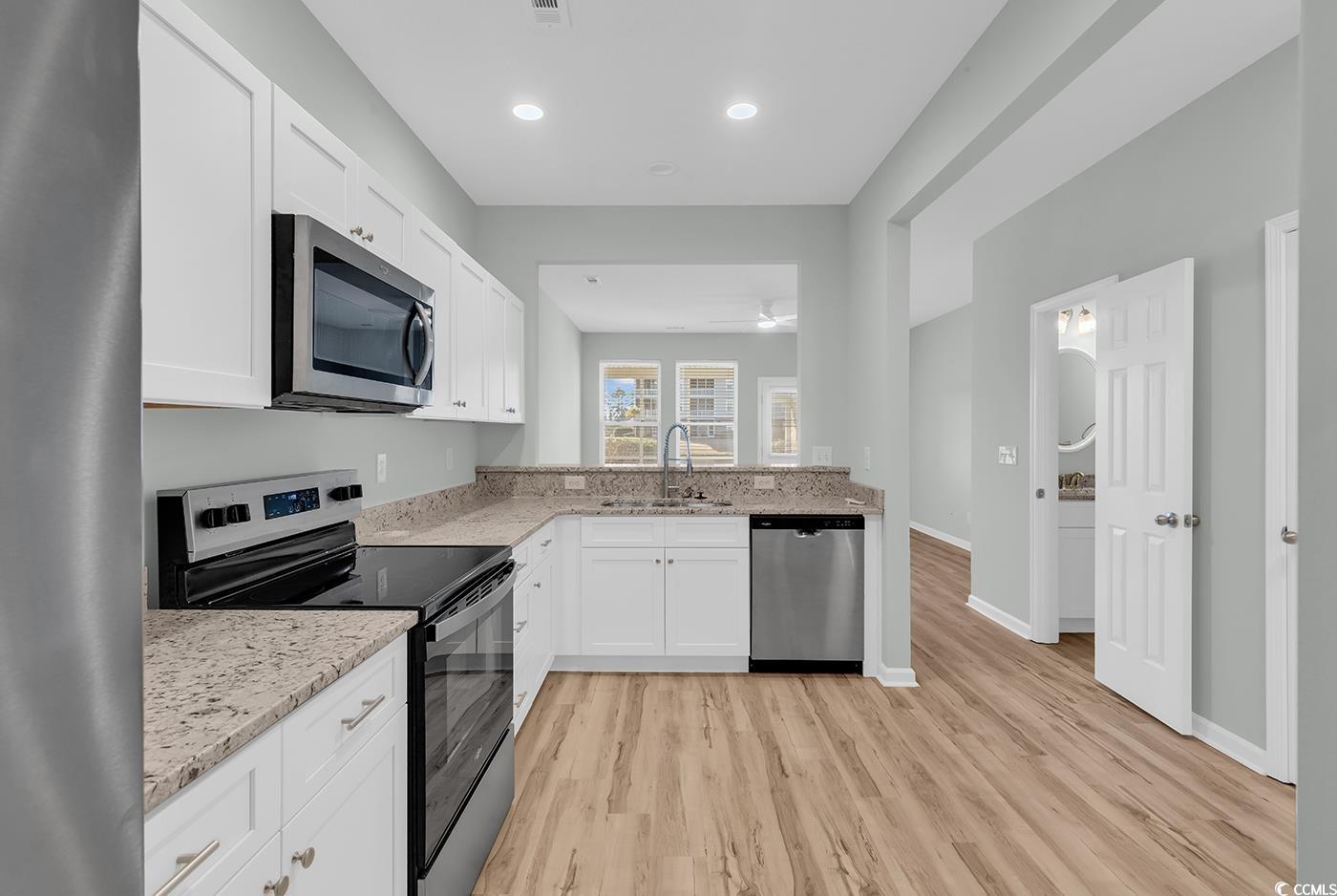 308 Kiskadee Loop, Unit E Conway, SC 29526 - Photo 7 of 36 Kitchen featuring stainless steel appliances, white cabinetry, light stone counters, light wood-type flooring, and recessed lighting