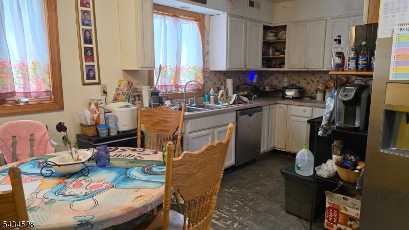 1115 West Camplain Road Manville, NJ 08835 - Photo 7 of 18 a kitchen with sink refrigerator dining table and chairs