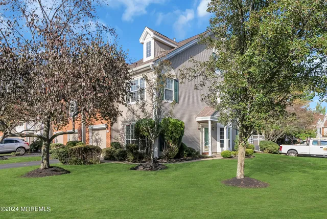 a view of a house with a big yard and large trees