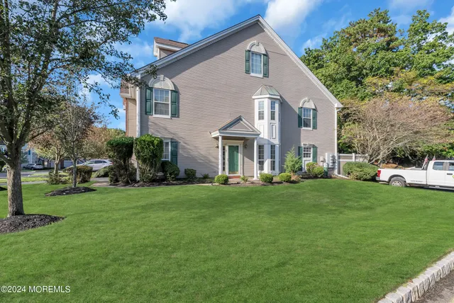 a front view of a house with a garden and plants