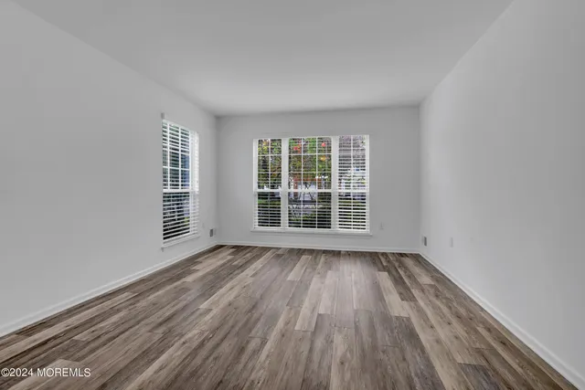 a view of a room with wooden floor and kitchen view