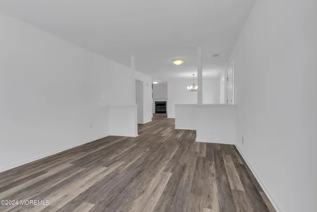 a view of a livingroom with a chandelier fan and wooden floor