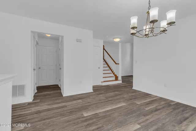 a view of a livingroom with wooden floor and a fireplace
