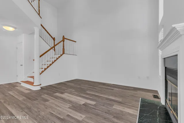 an empty room with wooden floor and a fireplace