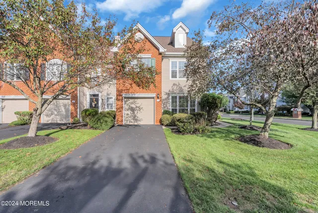 a front view of a house with a yard and trees