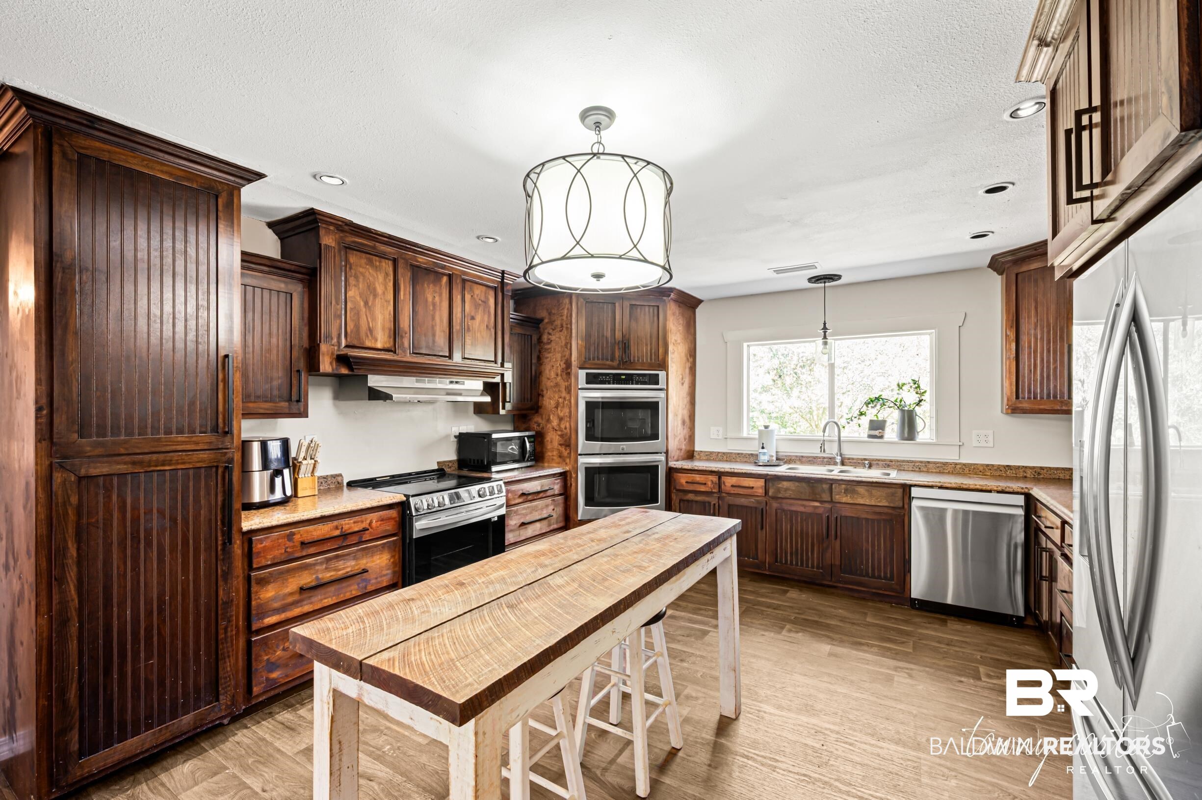 3086 Wild Fork Road Frisco City, AL 36445 - Photo 2 of 30 Kitchen featuring light wood finished floors, stainless steel appliances, pendant lighting, recessed lighting, and dark brown cabinets