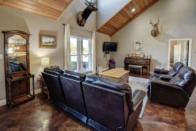a living room with furniture a flat screen tv and kitchen view