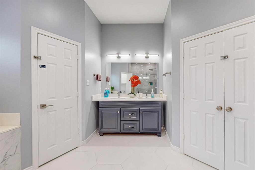 4908 Glenwood Lane Anna, TX 75409 - Photo 13 of 34 Primary bathroom featuring double vanity, a marble finish shower, light tile patterned floors, and a tub with marble appearance
