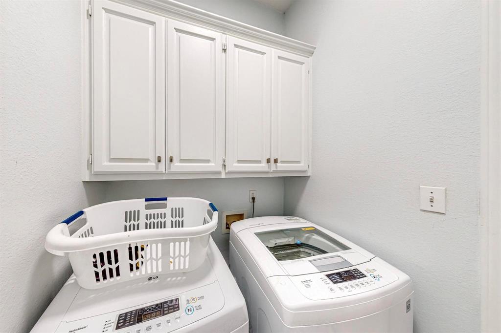 4908 Glenwood Lane Anna, TX 75409 - Photo 21 of 34 Laundry room with a textured wall, cabinet space, and washer and dryer