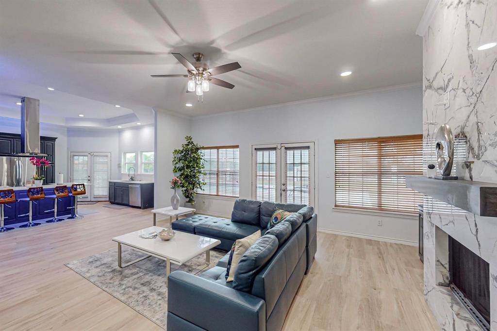 4908 Glenwood Lane Anna, TX 75409 - Photo 4 of 34 Living area with a premium fireplace, light wood-style floors, ceiling fan, recessed lighting, and french doors