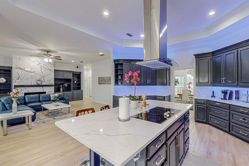 4908 Glenwood Lane Anna, TX 75409 - Photo 8 of 34 Kitchen with light wood-style flooring, a breakfast bar, a center island with sink, island exhaust hood, and recessed lighting