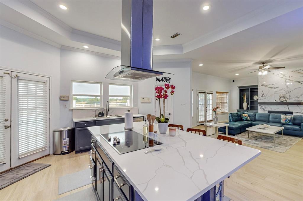 4908 Glenwood Lane Anna, TX 75409 - Photo 9 of 34 Kitchen featuring french doors, a raised ceiling, light wood-style flooring, island exhaust hood, and recessed lighting
