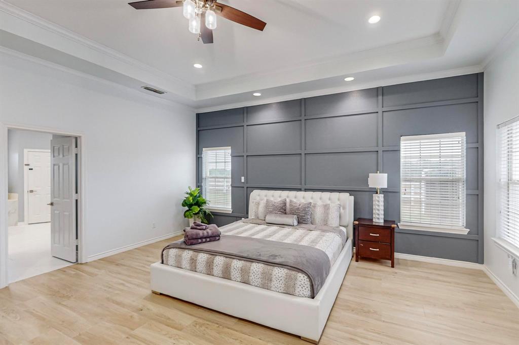 4908 Glenwood Lane Anna, TX 75409 - Photo 10 of 34 Bedroom featuring a raised ceiling, light wood-style floors, multiple windows, crown molding, and recessed lighting