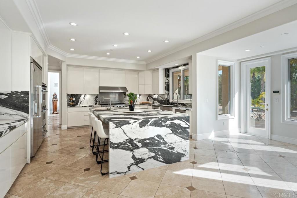 6773 Poco Lago Rancho Santa Fe, CA 92067 - Photo 25 of 65 a kitchen with stainless steel appliances kitchen island granite countertop a refrigerator and cabinets