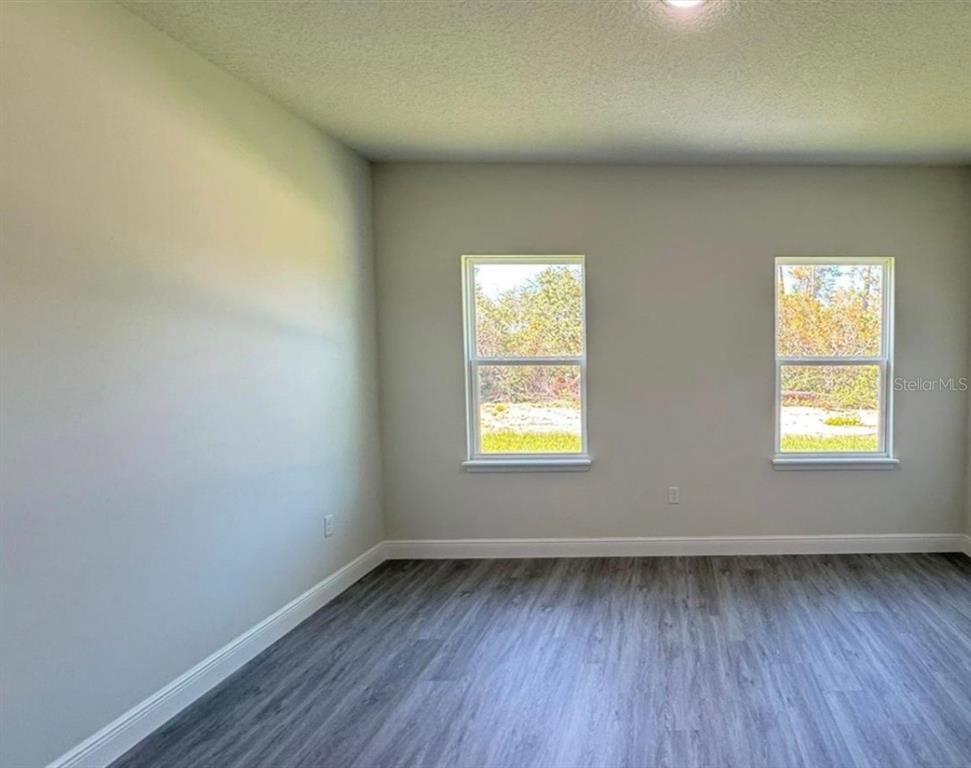 2500 Southwest 156th Lane Road Ocala, FL 34473 - Photo 5 of 15 an empty room with wooden floor and windows