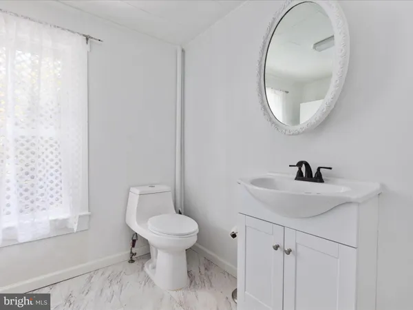 a bathroom with a sink a toilet and a mirror