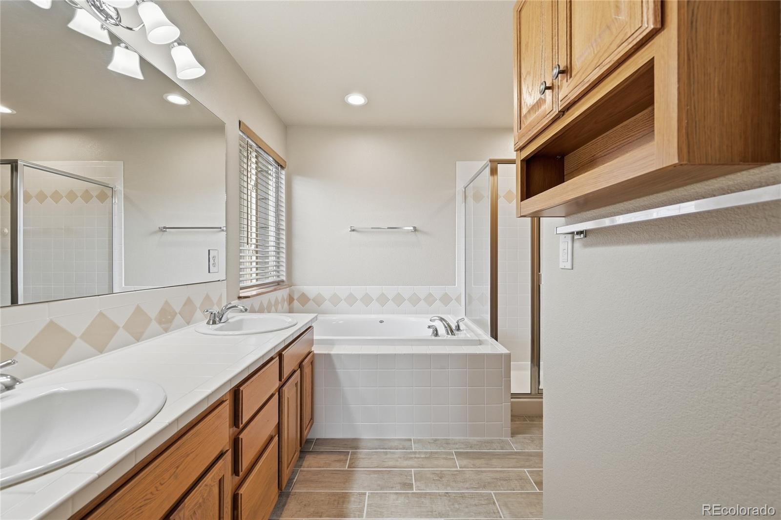 9288 Rockingham Drive Peyton, CO 80831 - Photo 18 of 49 a bathroom with a double vanity sink mirror and bathtub