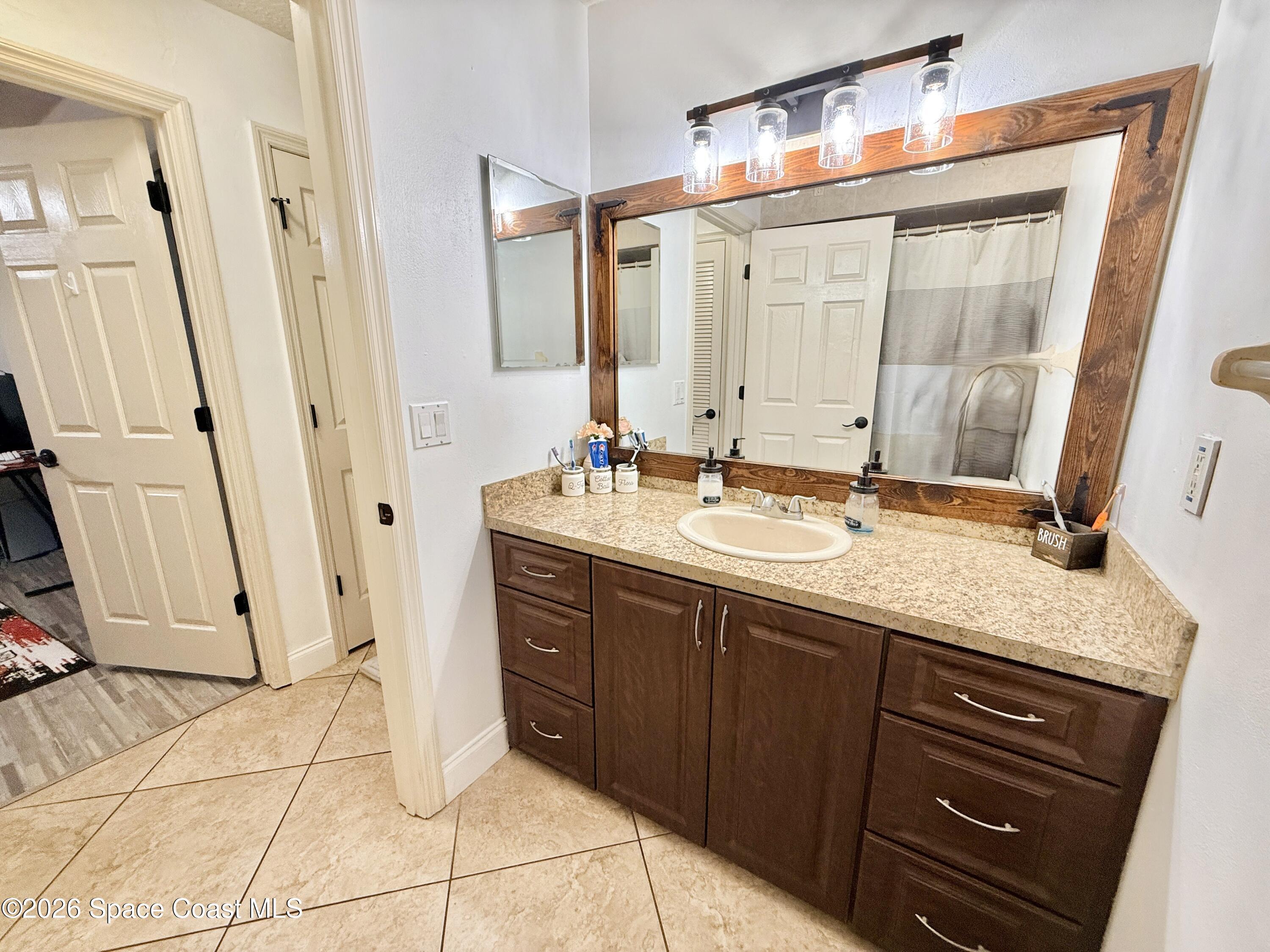 1046 West Samms Avenue Port Orange, FL 32129 - Photo 24 of 53 a bathroom with a granite countertop sink and a mirror