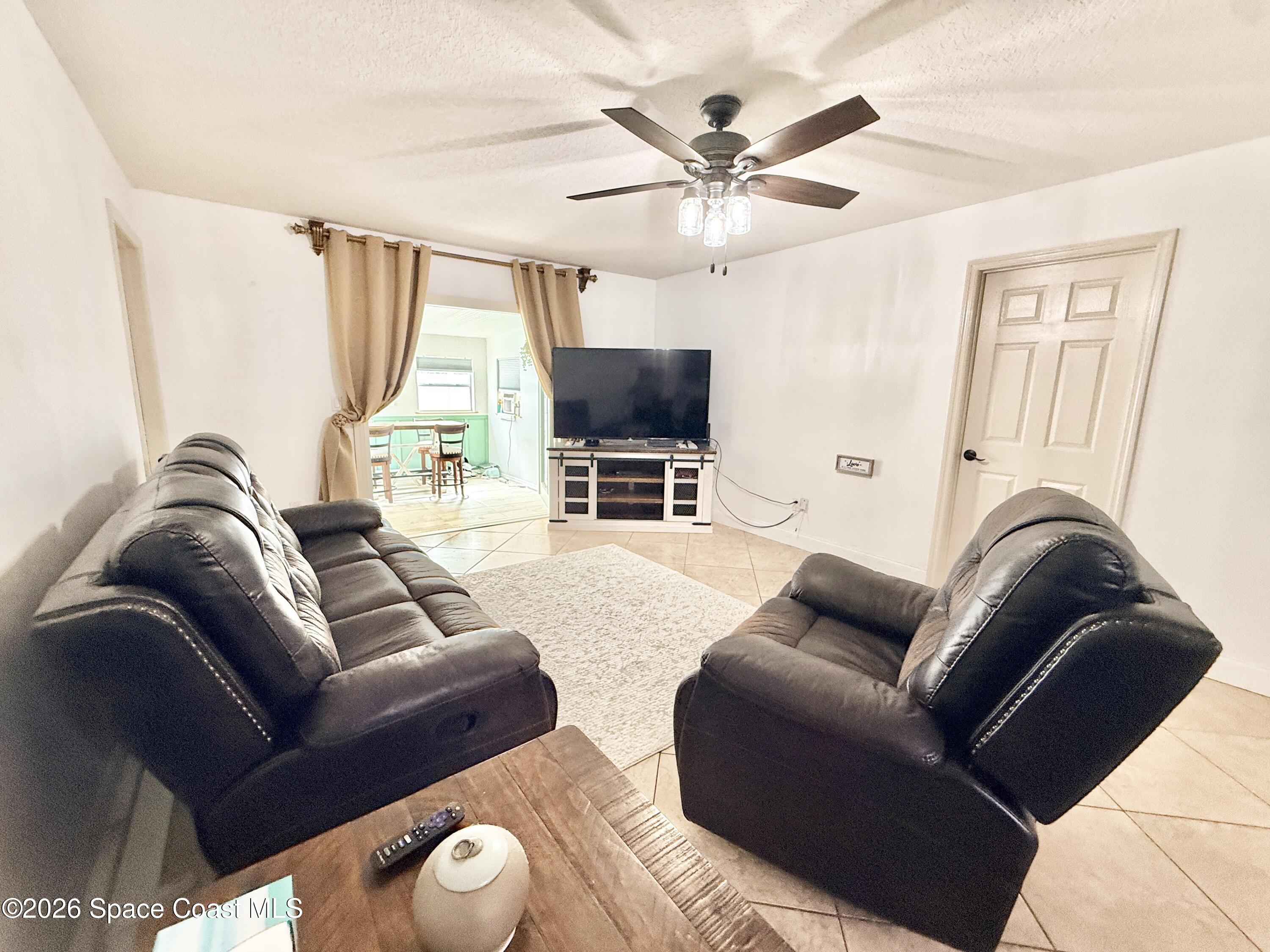 1046 West Samms Avenue Port Orange, FL 32129 - Photo 40 of 53 a living room with furniture a large window and a flat screen tv