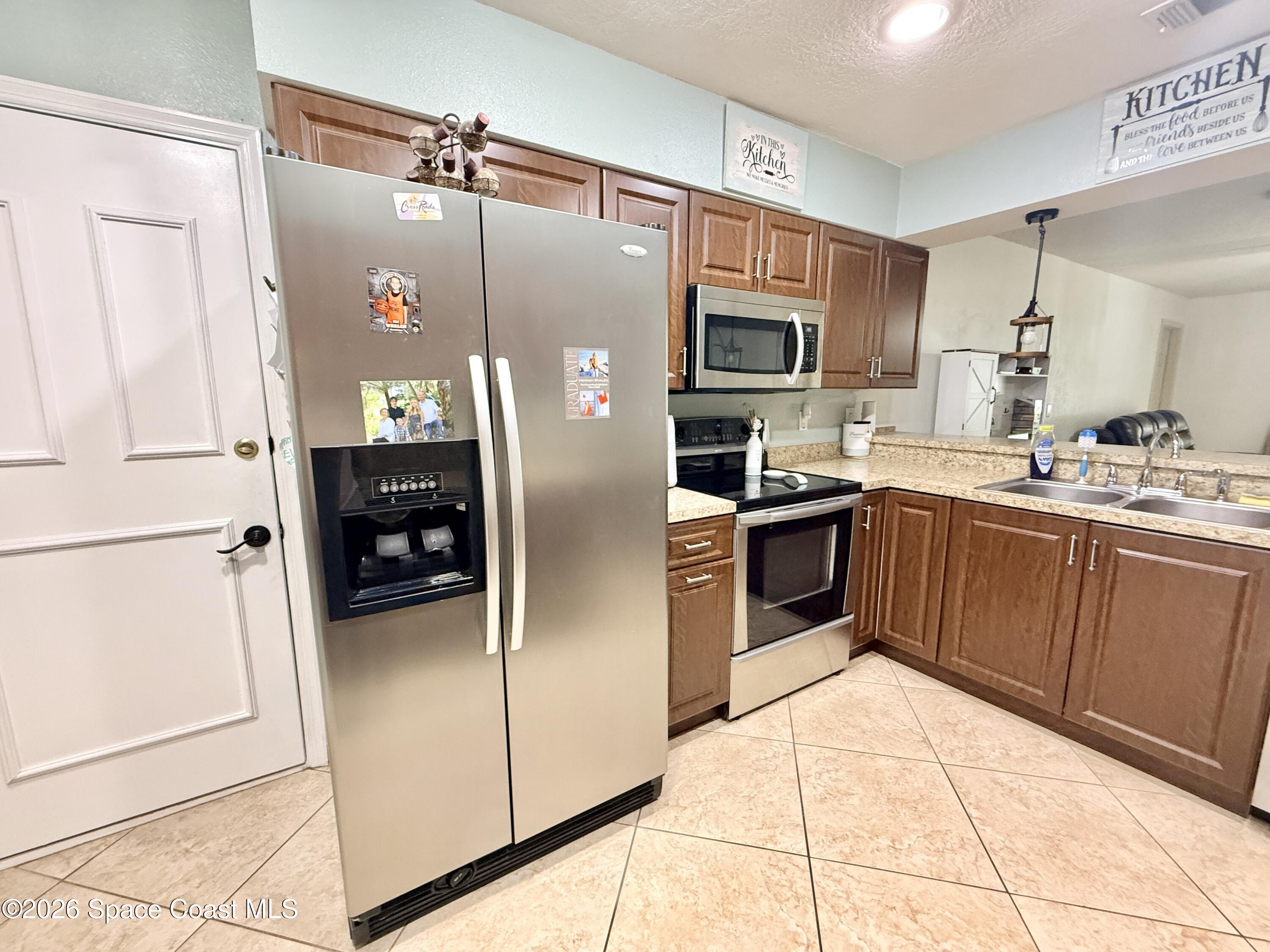 1046 West Samms Avenue Port Orange, FL 32129 - Photo 9 of 53 a kitchen with stainless steel appliances a refrigerator sink and microwave
