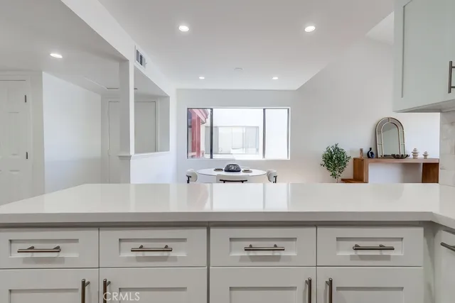 a kitchen with stainless steel appliances granite countertop a sink a stove and white cabinets