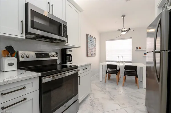 a kitchen with kitchen island granite countertop a stove top oven microwave and cabinets
