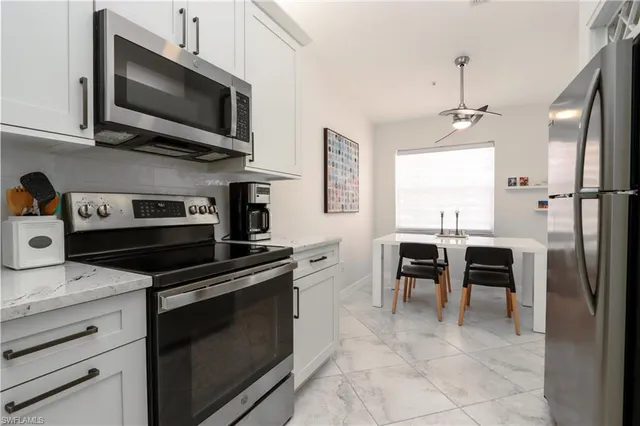 a kitchen with kitchen island granite countertop a stove top oven microwave and cabinets