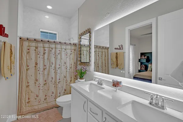 a bathroom with double vanity sink and mirror