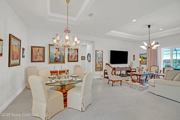 a view of a livingroom and a dining room with furniture window and wooden floor