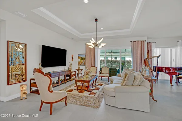a living room with furniture a flat screen tv and a large window