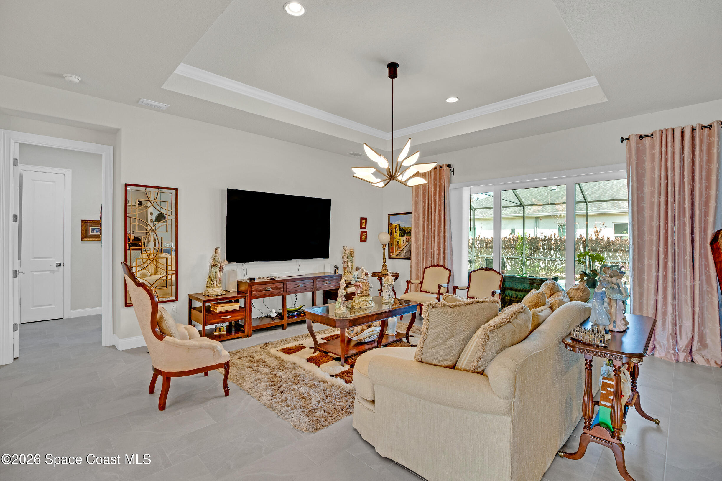 4160 Negal Circle Melbourne, FL 32901 - Photo 8 of 61 a living room with furniture a flat screen tv and a large window