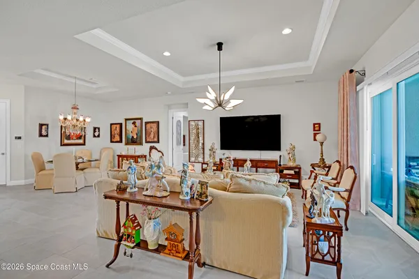 a living room with furniture a flat screen tv and a refrigerator