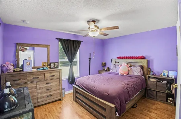 a bedroom with a bed a chandelier and dresser