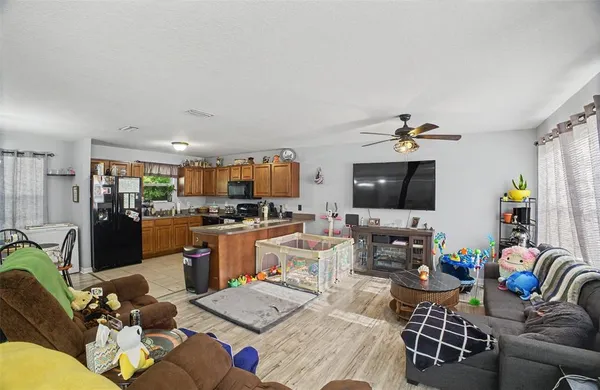 a living room with furniture kitchen view and a flat screen tv