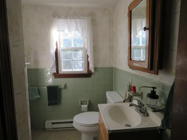 a bathroom with a sink toilet and a mirror