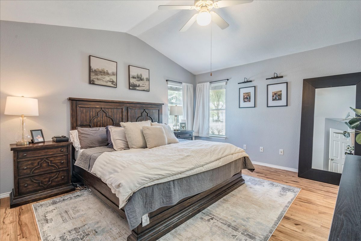175 Wetzel Kyle, TX 78640 - Photo 14 of 27 Discover comfort in this bedroom featuring a vaulted ceiling and rich hardwood flooring.